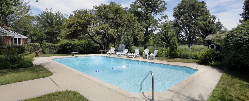 Swimming pool in suburban home with golf course view. poolside patio